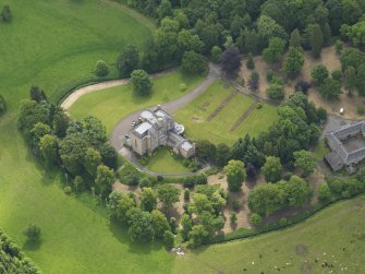 Oblique aerial view of Caprington Castle and stables, taken from the NW.