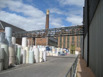 General view looking NW towards Boiler House (NO45120 19599). Wood Pulp Store (Building 1) to right of picture. Note pipe carrying pulped wood solution from the Pulper in the Wood Pulp Store to the Stock Preparation House (Building 2).