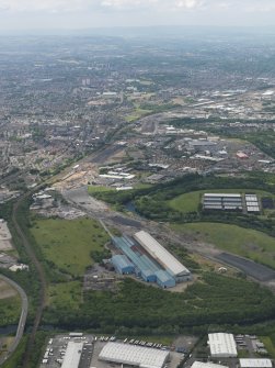 General oblique aerial view centred on the steel works with the motorway extension works adjacent, taken from the E.