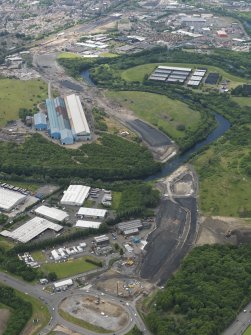 General oblique aerial view centred on the steel works with the motorway extension works adjacent, taken from the NE.