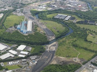 General oblique aerial view centred on the steel works with the motorway extension works adjacent, taken from the NE.