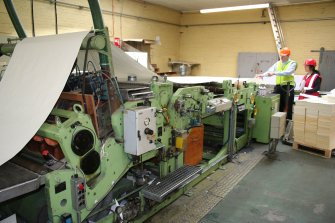 Interior. Adjacent to Building 7, Finishing section. View of sheeting machine cutter. Charles Whittaker (production manager) on left.