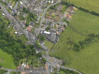 Oblique aerial view centred on the parish church with the school adjacent, taken from the NNW.