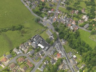 Oblique aerial view centred on the parish church with the school adjacent, taken from the SE.