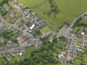 Oblique aerial view centred on the parish church with the school adjacent, taken from the NE.