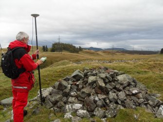 General view of Mr Ian Parker (RCAHMS) using differential GPS to survey a small cairn overlying the inner wall of the timber-laced fort.