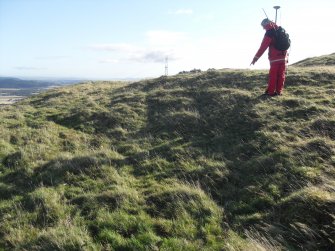 View from W of Mr Ian Parker (RCAHMS) using differential GPS to survey a circular house platform on the N side of the timber-laced fort.