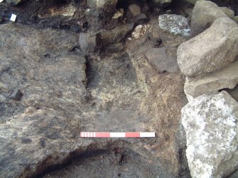 Trench 15 from NW showing excavated pit feature F15.11, possible features cut in abutting clay layer and relationship with F15.14  (scale = 0.5m)