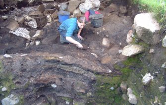Trench 15 from the N showing Gemma Cruickshanks excavating the ash layers to the NE of revetment wall F15.14