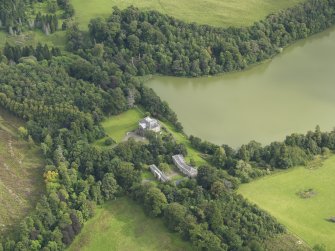 Oblique aerial view centred on the country house with the stable block adjacent, taken from the WNW.