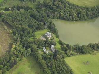 Oblique aerial view centred on the country house with the stable block adjacent, taken from the W.