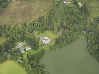 Oblique aerial view centred on the country house with the stable block adjacent, taken from the SW.