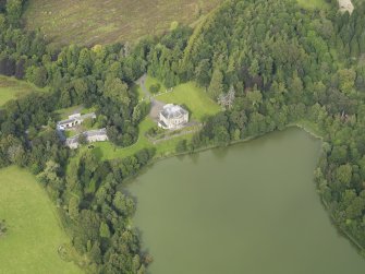 Oblique aerial view centred on the country house with the stable block adjacent, taken from the SSW.