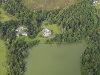 Oblique aerial view centred on the country house with the stable block adjacent, taken from the S.
