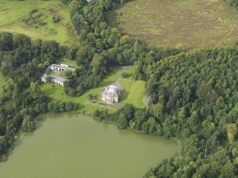 Oblique aerial view centred on the country house with the stable block adjacent, taken from the SSE.