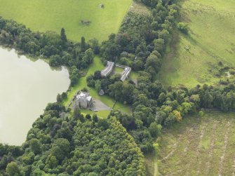 Oblique aerial view centred on the country house with the stable block adjacent, taken from the ENE.
