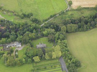 Oblique aerial view centred on the church with the churchyard and manse adjacent, taken from the SSE.