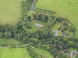 Oblique aerial view centred on the church with the churchyard and manse adjacent, taken from the NNW.