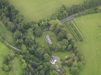 Oblique aerial view centred on the church with the churchyard and manse adjacent, taken from the W.