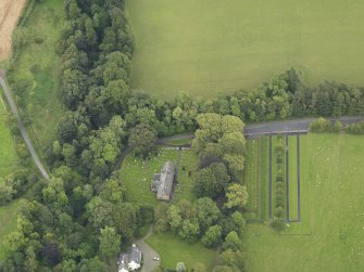 Oblique aerial view centred on the church with the churchyard and manse adjacent, taken from the WSW.