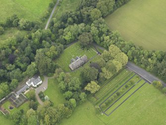 Oblique aerial view centred on the church with the churchyard and manse adjacent, taken from the SW.
