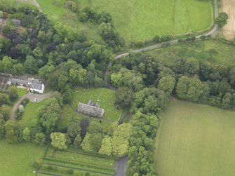 Oblique aerial view centred on the church with the churchyard and manse adjacent, taken from the SSE.