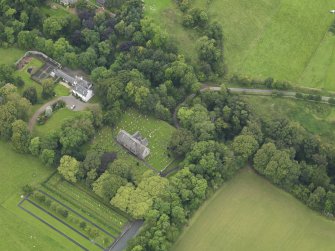 Oblique aerial view centred on the church with the churchyard and manse adjacent, taken from the SE.