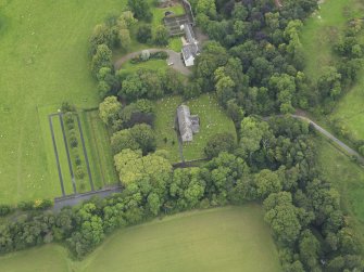 Oblique aerial view centred on the church with the churchyard and manse adjacent, taken from the ENE.