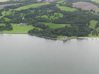 General oblique aerial view centred on the country house with Barnbougle Castle adjacent, taken from the N.