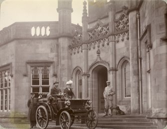 View of Inchrye Abbey entrance with couple in automobile.


