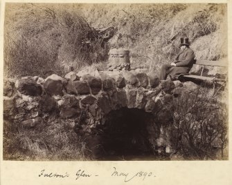 View of bridge and man on a bench.
Titled: 'Fulton's Glen - May 1890'. 
PHOTOGRAPH ALBUM NO 218: The Barrhead Album

