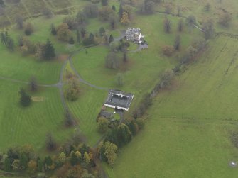 Oblique aerial view centred on the country house with the stables adjacent, taken from the NNE.