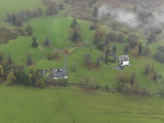 Oblique aerial view centred on the country house with the stables adjacent, taken from the WNW.