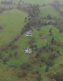Oblique aerial view centred on the country house with the stables adjacent, taken from the SSW.