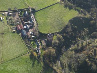 Oblique aerial view centred on the tower house with the farmstead adjacent, taken from the N.