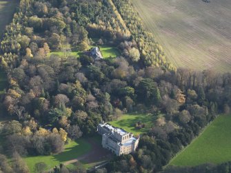 Oblique aerial view centred on the country house with the stable block adjacent, taken from the NW.