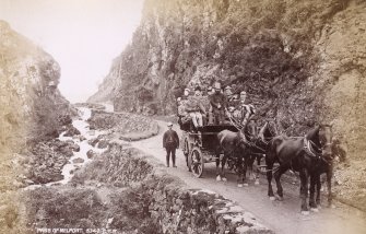 View of horse-drawn carriage with large group of people in the Pass of Melfort.
