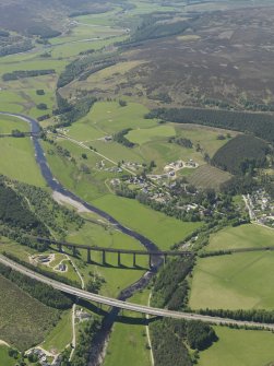 Oblique aerial view of Tomatin centred on the road bridge and railway viaduct with the village and Strath Dearn beyond, taken from the NE.