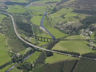 General oblique aerial view centred on the road bridge and railway viaduct with Tomatin village and Strath Dearn beyond, taken from the NNE.