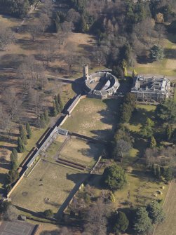 Oblique aerial view centred on the country house with the stable block and walled garden adjacent, taken from the SW.