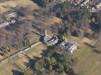 Oblique aerial view centred on the country house with the stable block adjacent, taken from the SW.