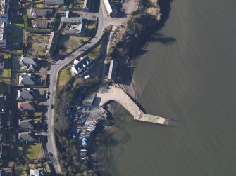 Oblique aerial view centred on the remains of the flying boat base with the harbour adjacent, taken from the E.