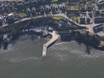 Oblique aerial view centred on the remains of the flying boat base with the harbour adjacent, taken from the N.