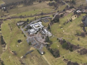Oblique aerial view centred on the country house with the country club adjacent, taken from the SSW.