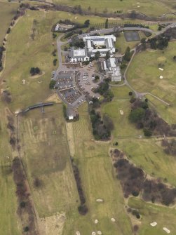 Oblique aerial view centred on the country house with the country club adjacent, taken from the SSE.