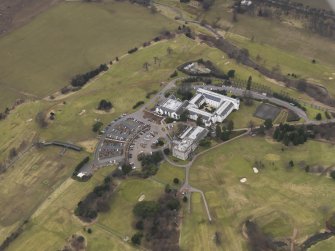 Oblique aerial view centred on the country house with the country club adjacent, taken from the SE.