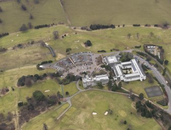 Oblique aerial view centred on the country house with the country club adjacent, taken from the E.