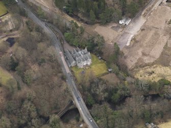 Oblique aerial view centred on the house with the road bridge adjacent, taken from the WSW.