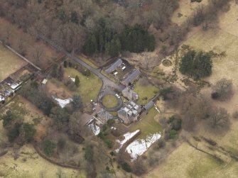 Oblique aerial view centred on the country house with the stable block, taken from the SSW.