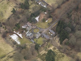 Oblique aerial view centred on the country house with the stable block, taken from the SE.